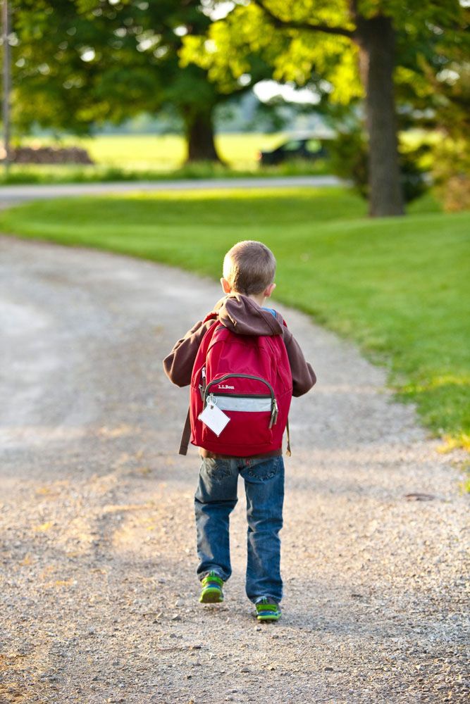 boy-in-brown-hoodie-carrying-red-backpack-while-walking-on.jpg